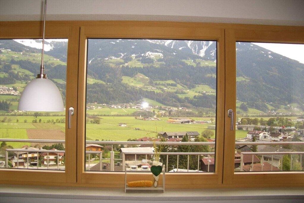 A room with a large window overlooking a mountainous landscape.