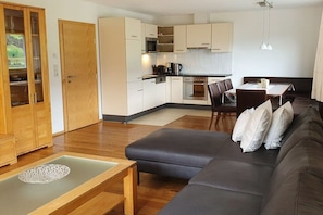 A modern living room with a sofa, a coffee table, and a dining area with a table and chairs. - Apartment in Fügen with swimming pool (Fügen)