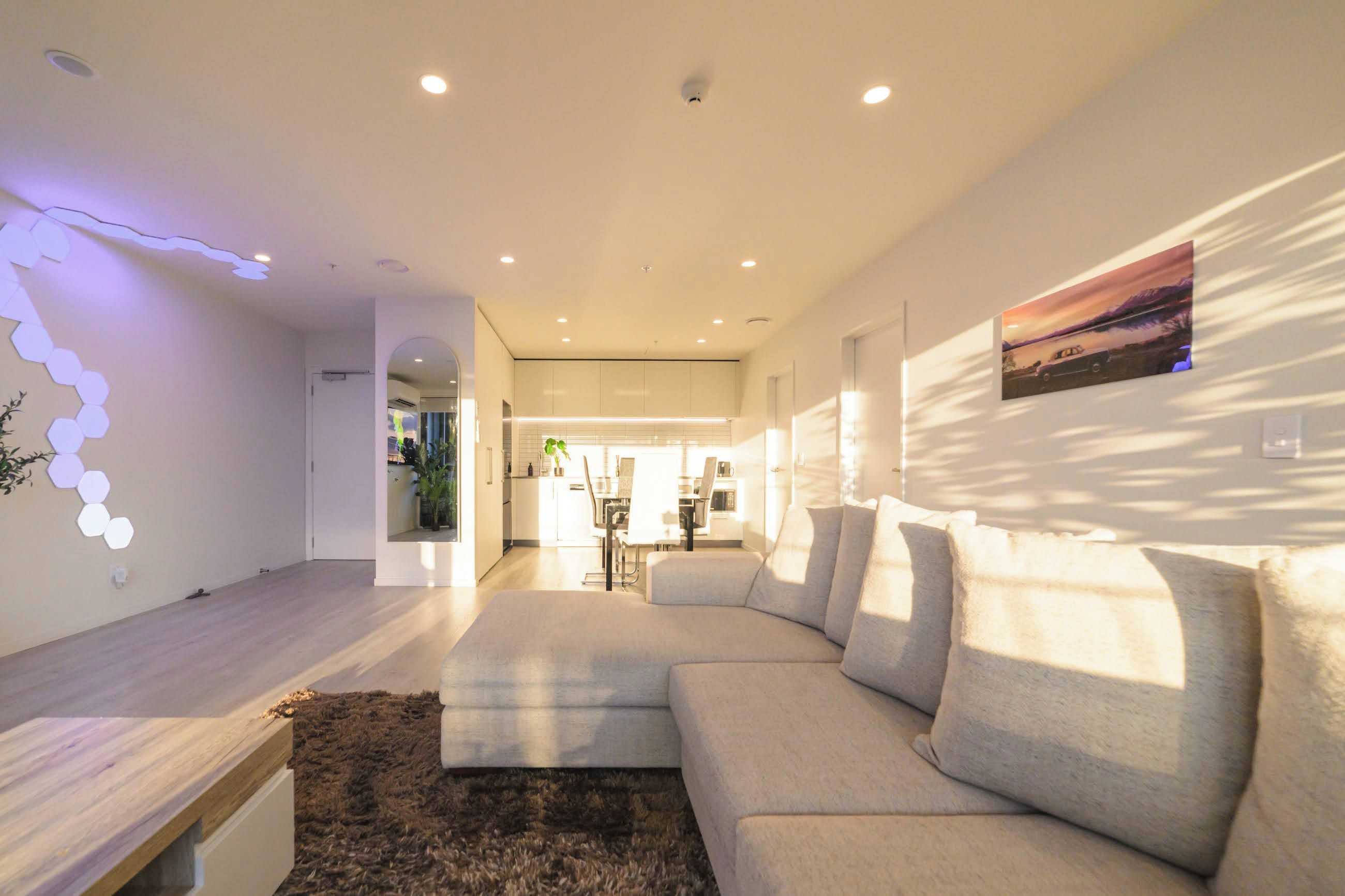 A modern living room with a sectional sofa, a wooden coffee table, and a wall-mounted picture.