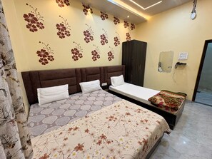 Quarto com cama grande, duas mesas de cabeceira, guarda-roupa e luminária fixada na parede.