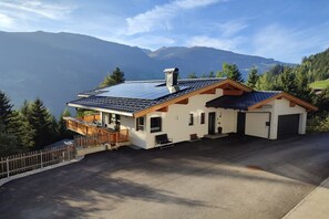 A modern house with a sloped roof, solar panels, and a view of mountains. - Holiday apartment with 1 bedroom (Ramsau)