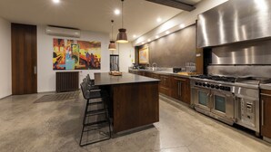 A modern kitchen with a central island, stainless steel appliances, and pendant lighting. - Melbourne City Apartments Luxury Loft House with rooftop (Southbank)