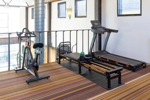 A fitness area with a stationary bike, treadmill, and exercise ball. - Melbourne City Apartments Luxury Loft House with rooftop (Southbank)