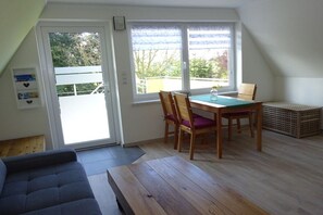 A room with a dining table, chairs, a bench, and a view through a door. - Holiday apartment with 1 bedroom (Vielist)