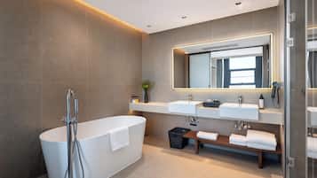 Un baño moderno con una bañera independiente, dos lavamanos, un espejo grande y un box de ducha de vidrio.