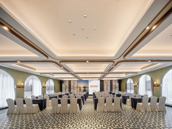 Un salón de conferencias con mesas y sillas dispuestas para una reunión.