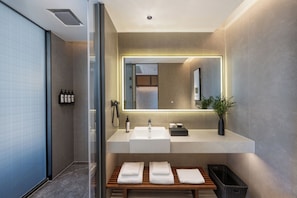 A modern bathroom with a large mirror, a sink, and a bench with towels. - SSAW Hotel Hefei Feixi University Town (Hefei)