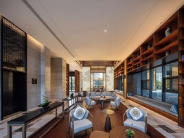 A modern interior with a seating area, wooden shelves, and large windows.