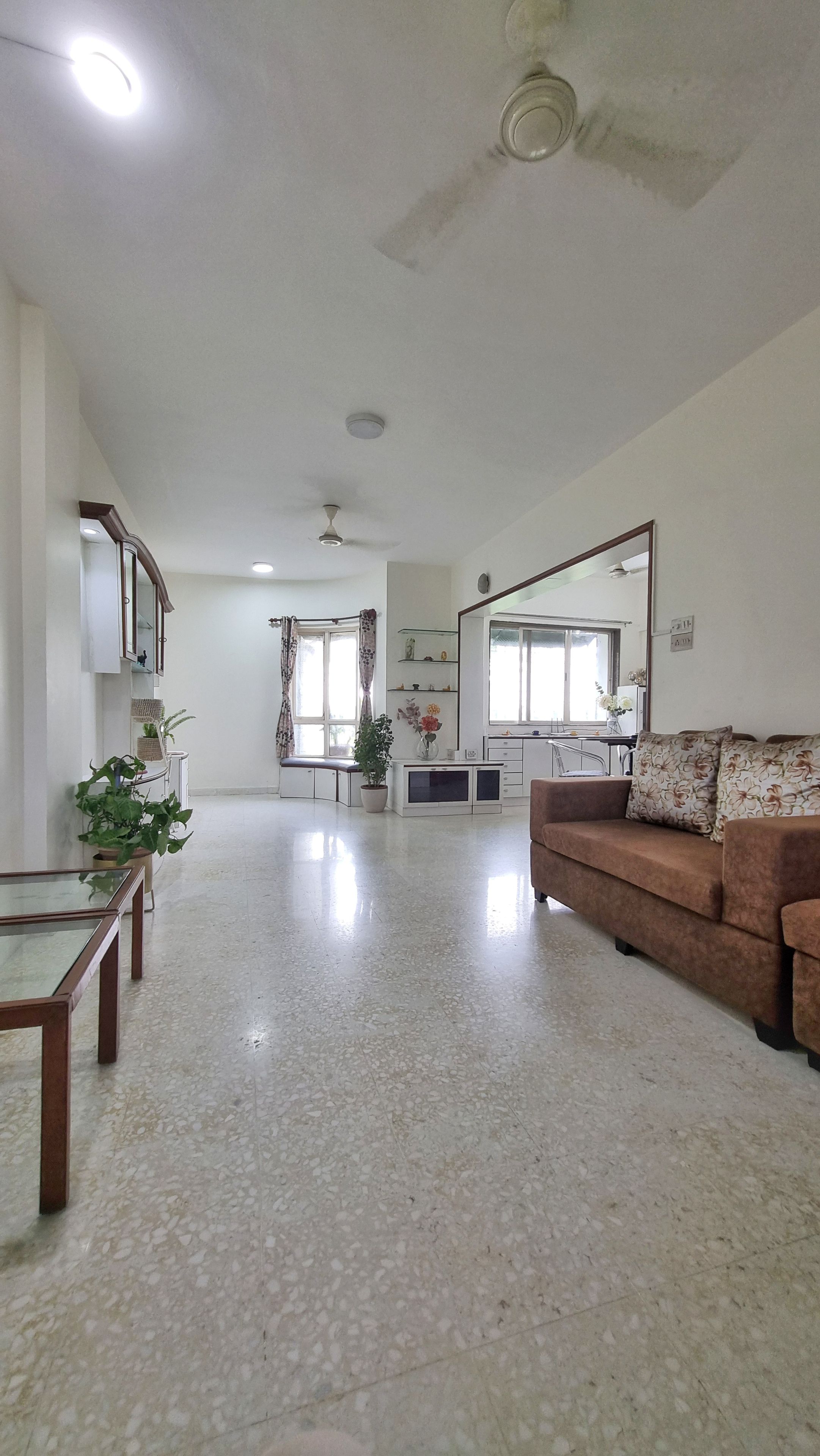 Amplia sala de estar con sofá, mesa de comedor y cocina al fondo.