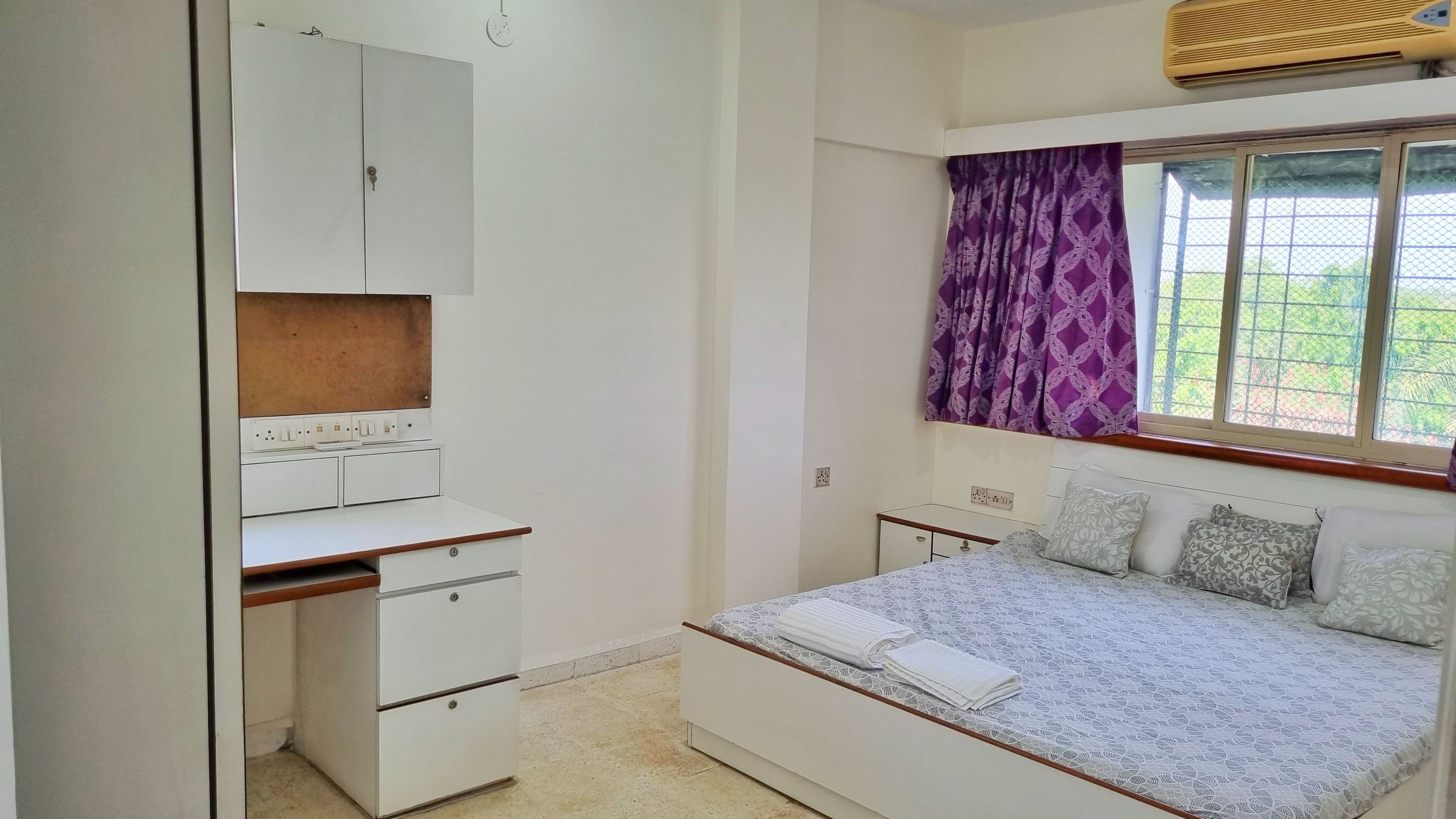 Un dormitorio con una cama, un escritorio y un armario.
