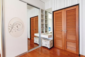 A room with a mirrored closet door, a white console table, and a wooden wardrobe. - Modern 2BR Beachside Pool Villa (BA2) (Sattahip)