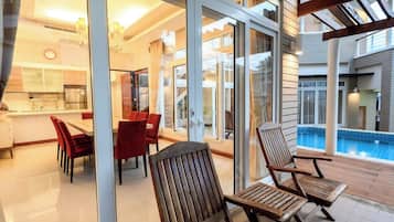 Um interior moderno com área de jantar, cozinha e vista para uma piscina.