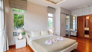 Quarto de hotel com cama, mesas de cabeceira, guarda-roupa e banheiro com espelho.