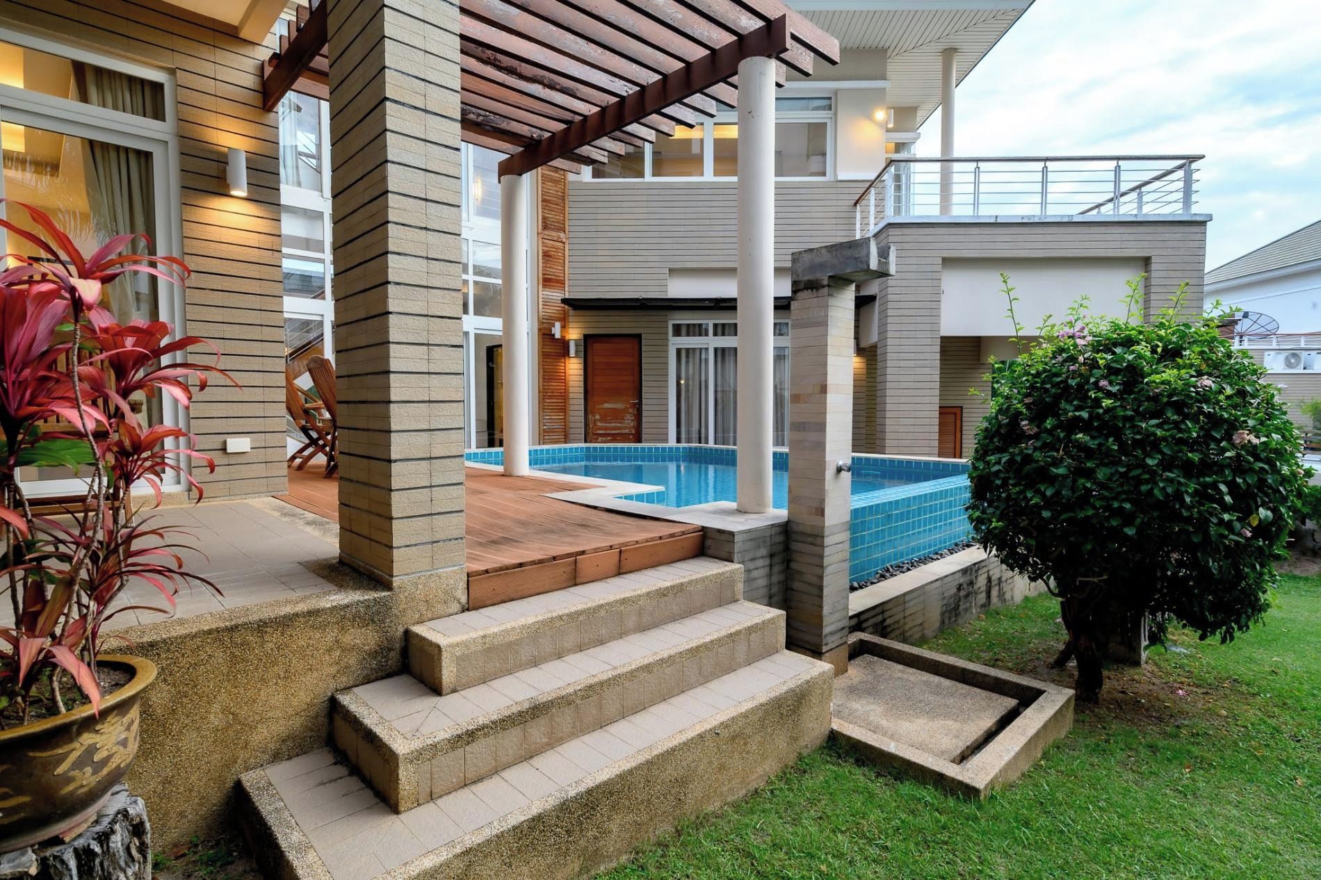 Une maison moderne dotée d’une piscine, d’un patio couvert et d’un jardin bien entretenu.