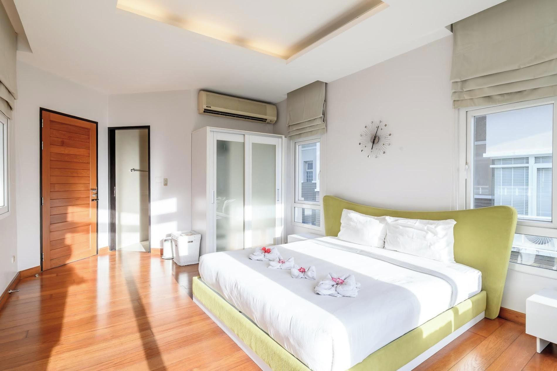 Habitación de hotel con una cama grande, un armario, un equipo de aire acondicionado y una ventana con vistas.