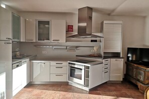 A compact kitchen with integrated appliances, a built-in oven, and a microwave. - Apartment Steinberger (Ramsau im Zillertal)
