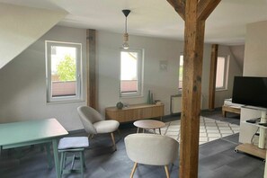 A modern living room with a dining area, a television, and a large window. - LEE Anchorage Priepert (Priepert)