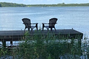 A wooden dock with two Adirondack chairs facing a calm lake. - LEE Anchorage Priepert (Priepert)