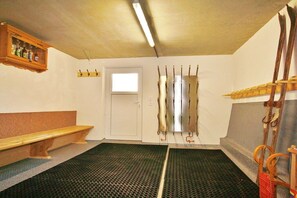 A room with a bench, a coat rack, a door, and a window.
