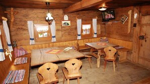 A wooden interior with a bench seating area, tables, and chairs. - Holiday cabin Donnerhäusl (Hippach)