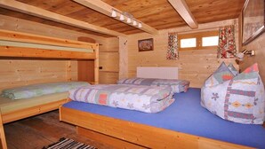 A wooden cabin interior with bunk beds, a blue mattress, and a radiator. - Holiday cabin Donnerhäusl (Hippach)