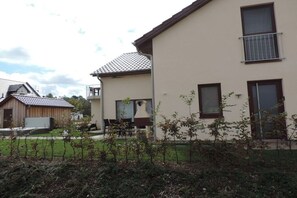 A residential building with a flat roof, a balcony, and a small garden area. - Holiday home with 2 bedrooms (Göhren-Lebbin)