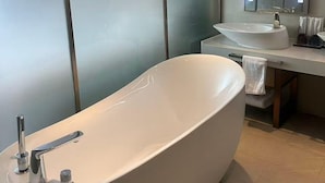 A modern bathroom with a freestanding bathtub, a sink, and a mirror. - Lavande Hotels Harbin Railway Station Zhanqian Square (Harbin)