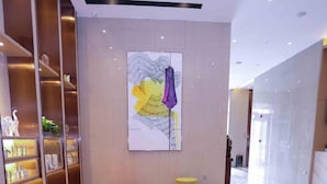 A modern lobby with a marble floor, red and white seating areas, and a large abstract painting on the wall. - Lavande Hotels Harbin Railway Station Zhanqian Square (Harbin)