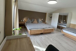 Ein Schlafzimmer mit einem großen Bett, Nachttischen, einem Schreibtisch und einem Spiegel.