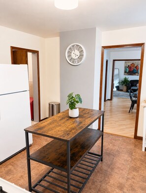 A modern kitchen with a wooden table, a clock, and a potted plant. - Cozy 2-Bed Chicago Retreat Near Chinatown & McCormick Place! Free street parking (Chicago)