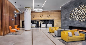 A modern lobby with a central column, seating areas, a fireplace, and a reception desk. - Yu'an Hotel Guangzhou Zhujiang New Town (Guangzhou)