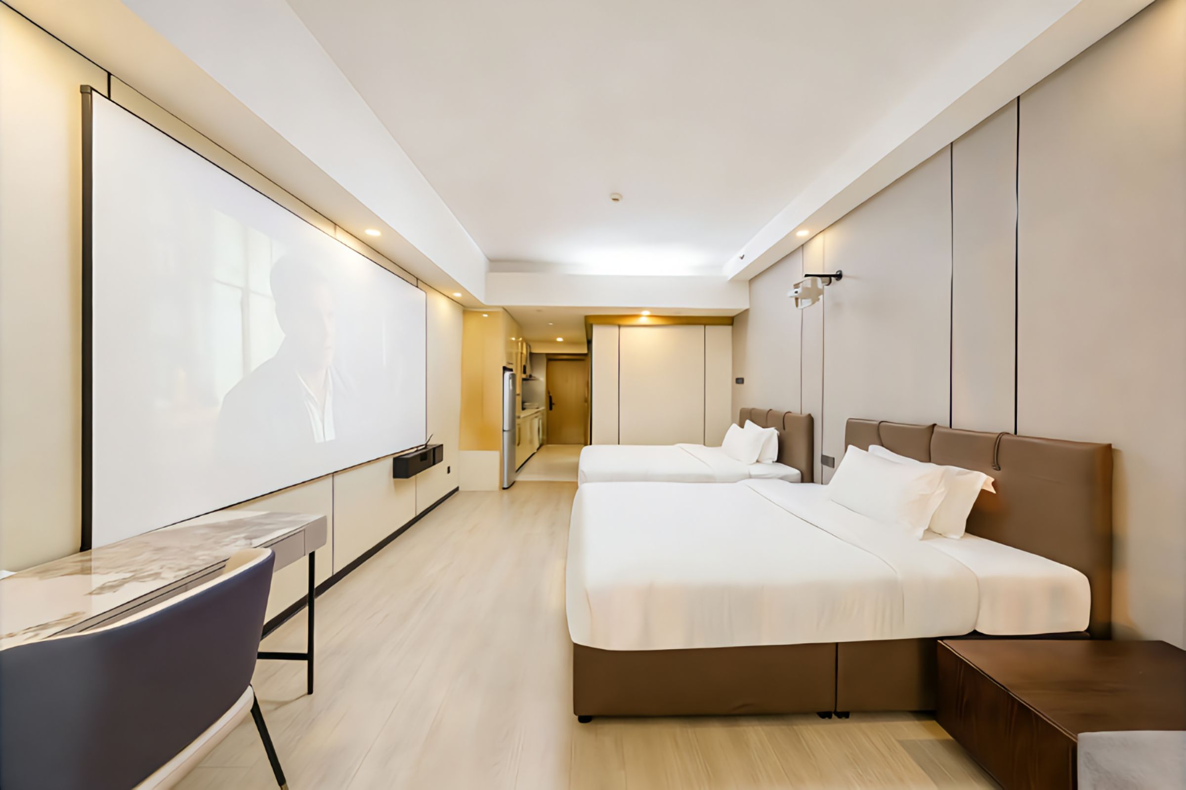 Una habitación de hotel con una cama, mesitas de noche, un escritorio y una silla.