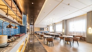 A modern restaurant with a long counter, multiple seating areas, and a mix of natural and artificial lighting. - Yu'an Hotel Guangzhou Zhujiang New Town (Guangzhou)