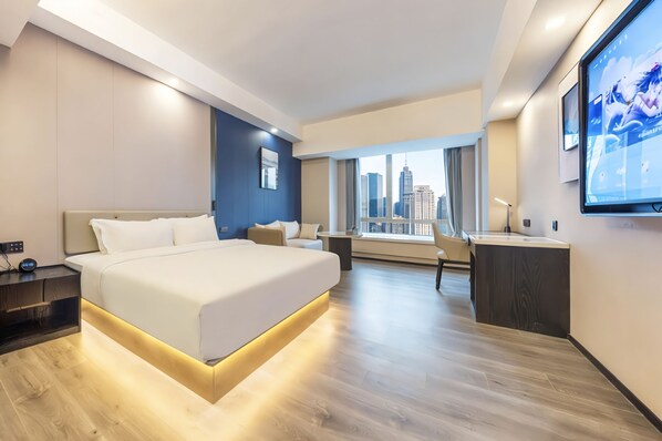 Una habitación de hotel moderna con una cama grande, un escritorio y vistas a la ciudad.