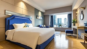 A modern hotel room with a large bed, a desk, and a view of the cityscape. - Yu'an Hotel Guangzhou Zhujiang New Town (Guangzhou)