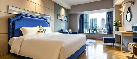 A modern hotel room with a large bed, a desk, and a view of the cityscape.