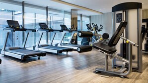 Un gimnasio moderno con cintas de correr, elípticas y equipo de levantamiento de pesas.