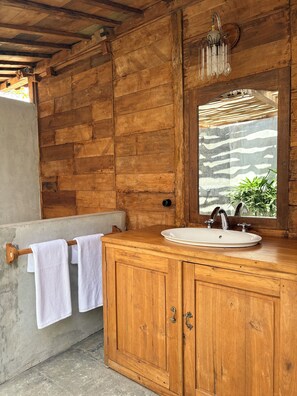 A wooden bathroom with a sink, mirror, and towel rack. - La Colline Nusa Penida (Penida Island)
