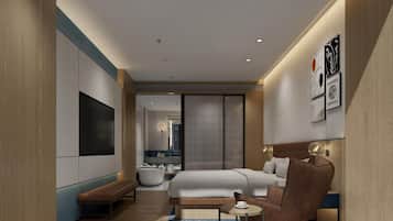 A modern hotel room with a bed, seating area, and a TV.