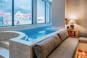 Un área de spa con una bañera de hidromasaje, un sofá y una lámpara.