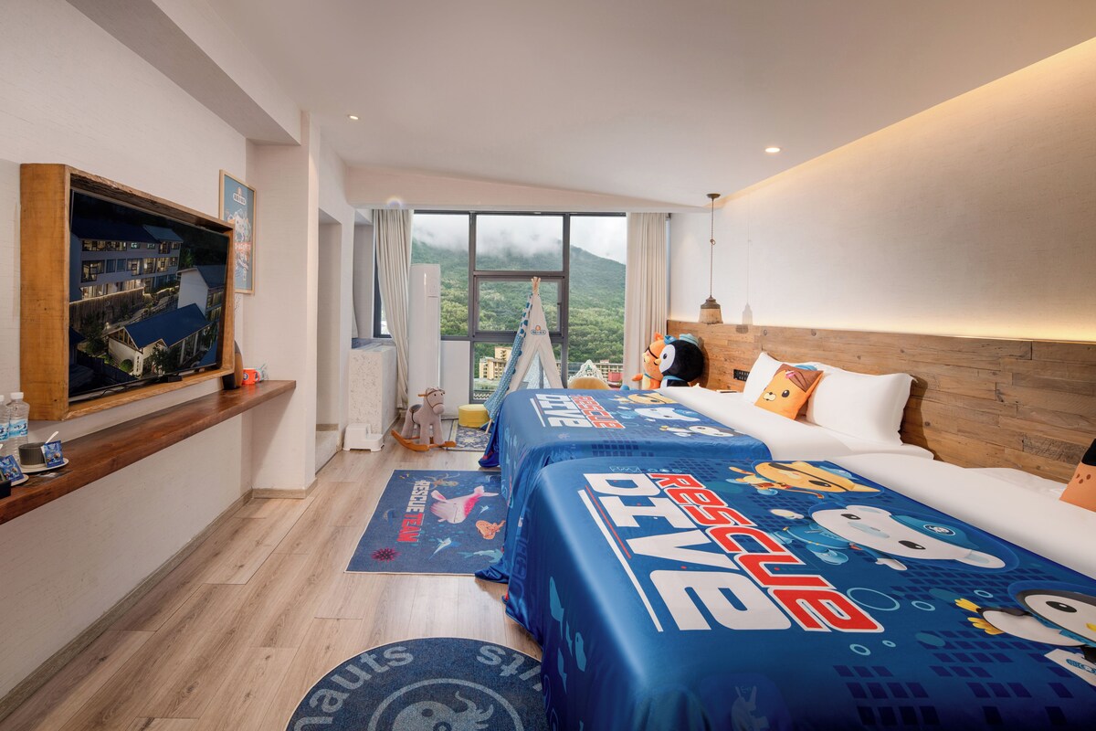 Une chambre d’hôtel avec un grand lit, un téléviseur fixé au mur et une vue sur un paysage montagneux.
