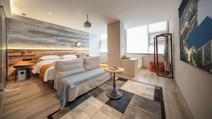 Une chambre d’hôtel moderne dotée d’un lit, d’un coin salon et offrant une vue sur la ville.