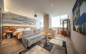 Une chambre d’hôtel moderne dotée d’un lit, d’un coin salon et offrant une vue sur la ville.