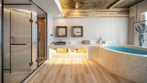 Ein modernes Badezimmer mit einer freistehenden Badewanne, einer Duschkabine aus Glas und einem Waschtisch.