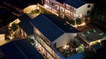 Um hotel com vários andares, áreas de estar ao ar livre e piscina no terraço.