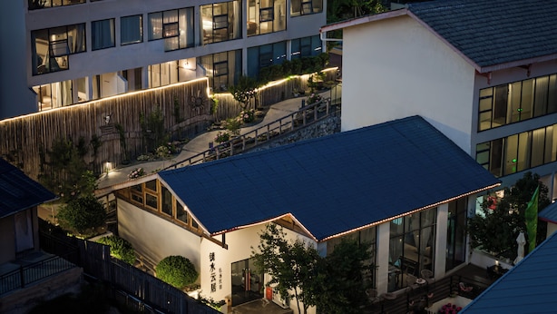 Un immeuble à plusieurs étages doté d’une architecture moderne, caractérisé par de grandes fenêtres et une façade bien éclairée.