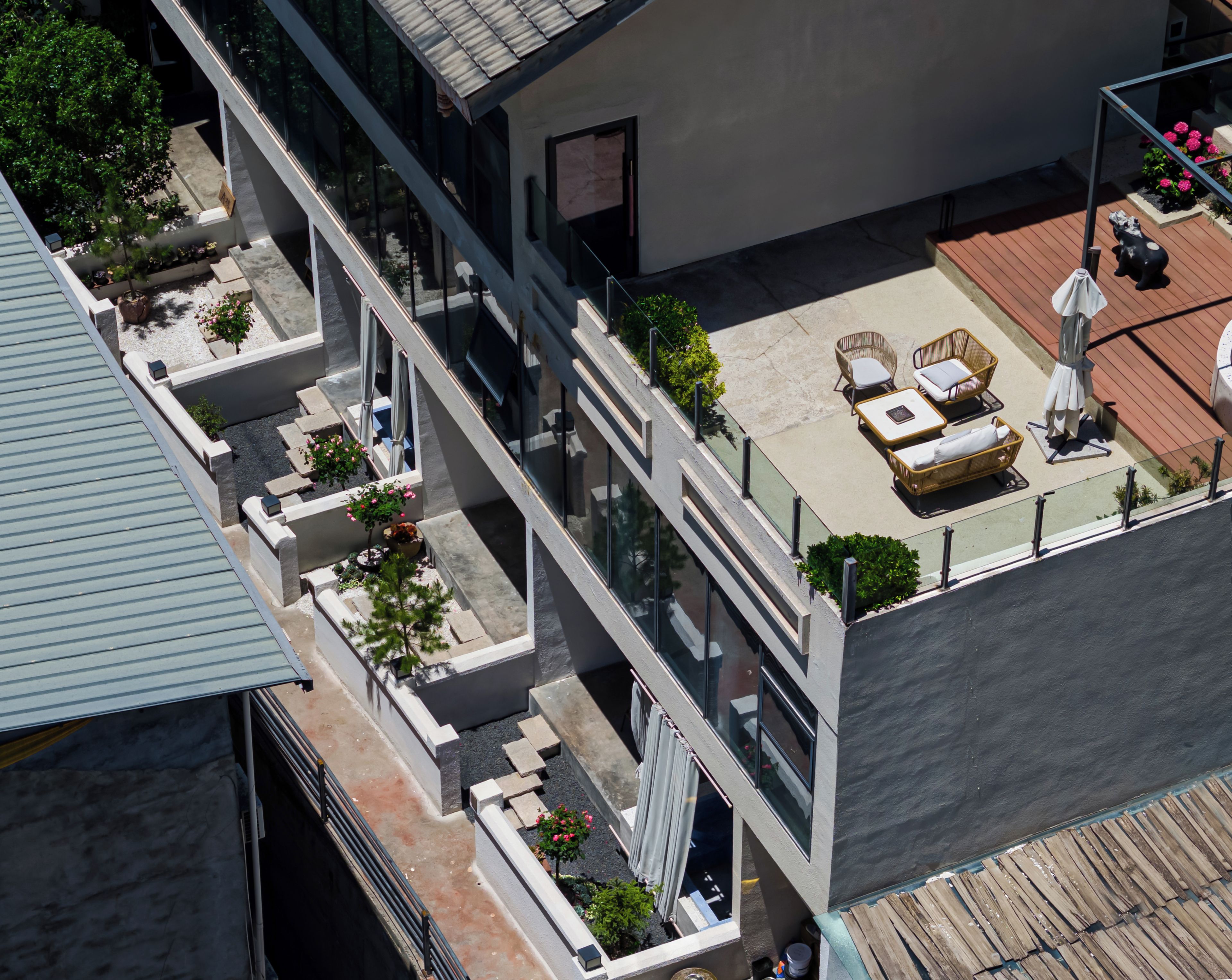 Edifici modern amb terrassa al terrat que disposa de mobiliari exterior, un jardí petit i una estàtua decorativa d'un os.