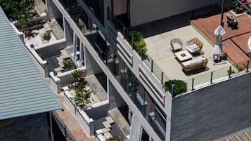 Edifici modern amb terrassa al terrat que disposa de mobiliari exterior, un jardí petit i una estàtua decorativa d'un os.