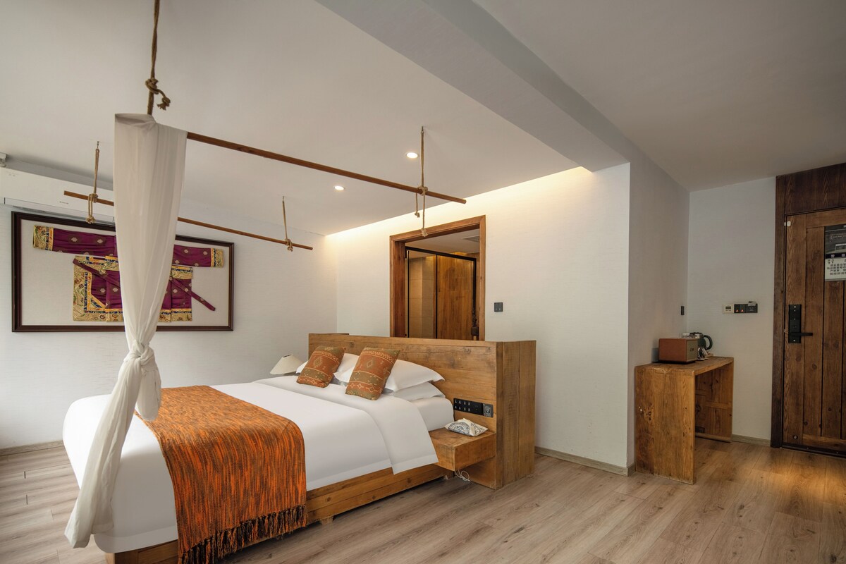 Une chambre à coucher moderne avec un lit en bois, une table de chevet, un miroir et une armoire en bois.