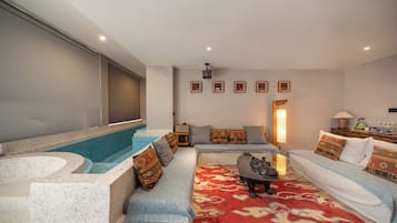 Una sala de estar moderna con bañera de hidromasaje, zona de estar y pantalla de proyector.